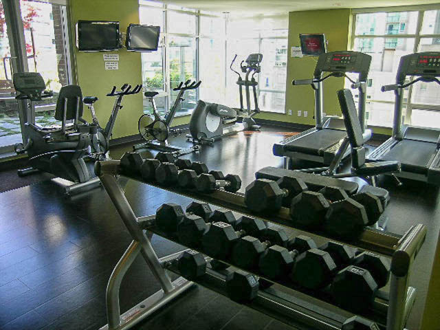 Bright gym with hardwood floors, city view, and exercise equipment. - 1003 - 535 Smithe St, Vancouver Downtown