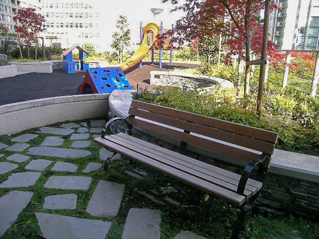 Outdoor seating area with benches and a playground in the background. - 1003 - 535 Smithe St, Vancouver Downtown