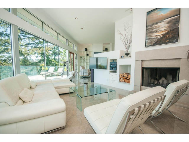 Spacious living room with modern furniture, glass coffee table, and ocean view. - 5517 Ocean Place, West Vancouver
