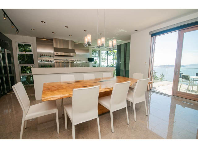 Bright dining area with hardwood floors, city view, and modern chandelier. - 5517 Ocean Place, West Vancouver
