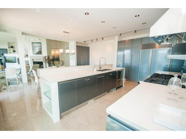Bright kitchen with modern design, white countertops, stainless steel appliances, and city view. - 5517 Ocean Place, West Vancouver