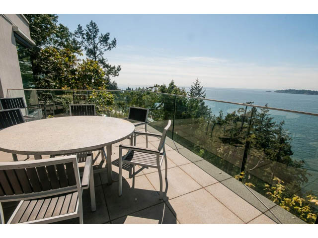 Furnished patio with ocean view and glass railing. - 5517 Ocean Place, West Vancouver