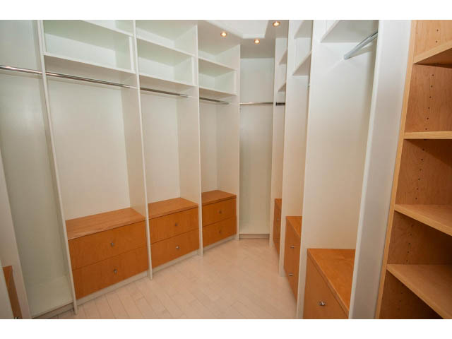 Spacious walk-in closet with white and wood shelving, hardwood floors. - 5517 Ocean Place, West Vancouver