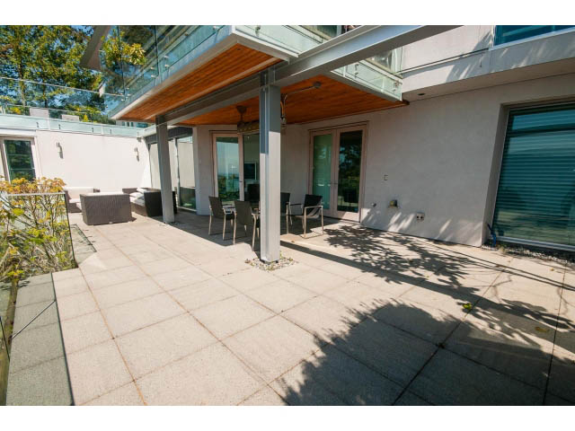Furnished patio with wooden ceiling, modern furniture, and city view. - 5517 Ocean Place, West Vancouver