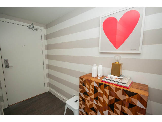 Bright den with striped walls, wooden furniture, and a bold heart artwork. - 2606 - 1325 Rolston Street, Vancouver Downtown