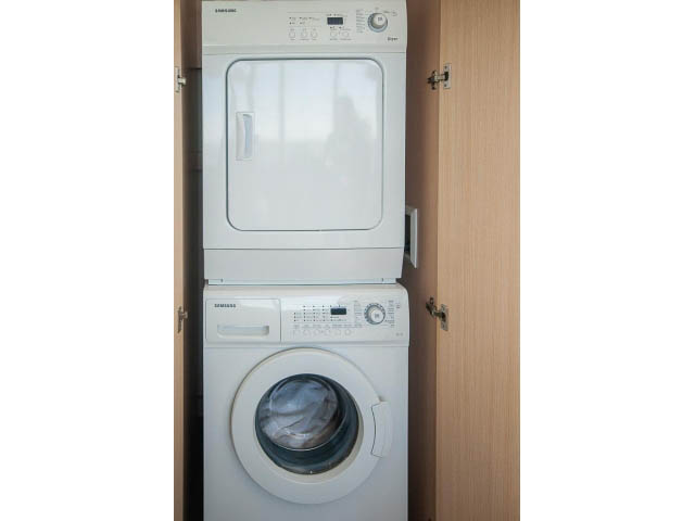 Bright laundry room with stacked washer and dryer, modern design. - 2606 - 1325 Rolston Street, Vancouver Downtown
