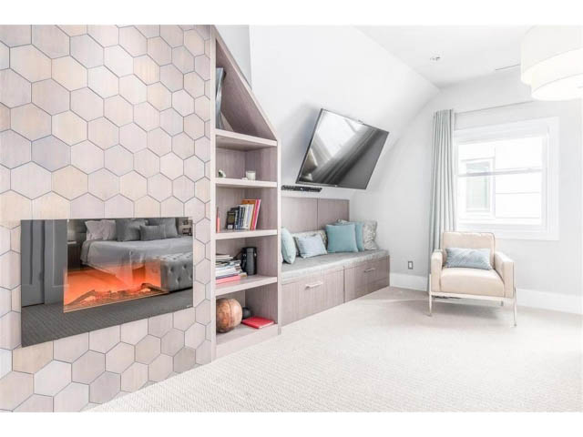 Bright living room with hexagonal tile accent wall and built-in shelving. - 1 - 2888 Birch Street, Vancouver West Side