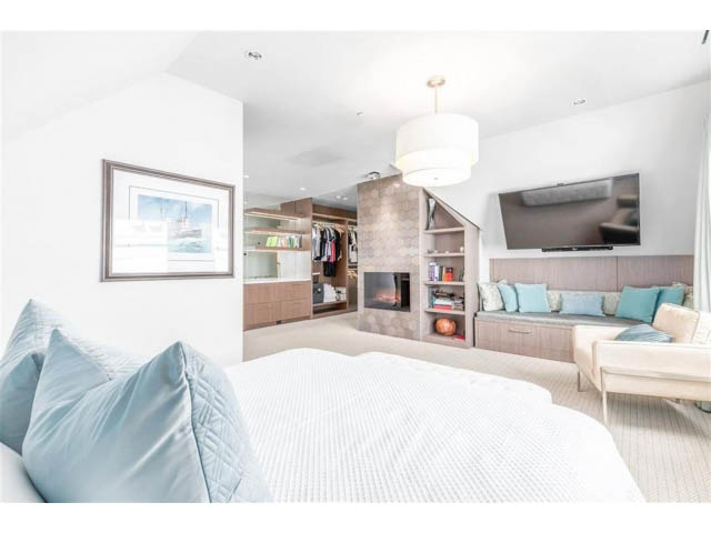 Spacious bedroom with cozy bedding, built-in shelves, and a flat-screen TV. - 1 - 2888 Birch Street, Vancouver West Side