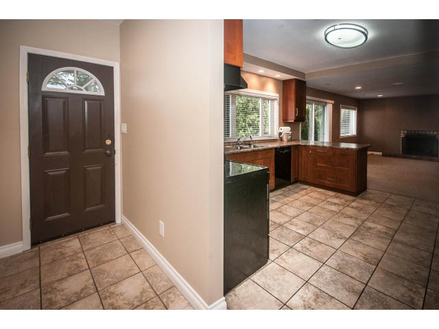 Bright kitchen with dark cabinetry and tiled flooring. - Lower - 5237 Timberfeild Road, West Vancouver