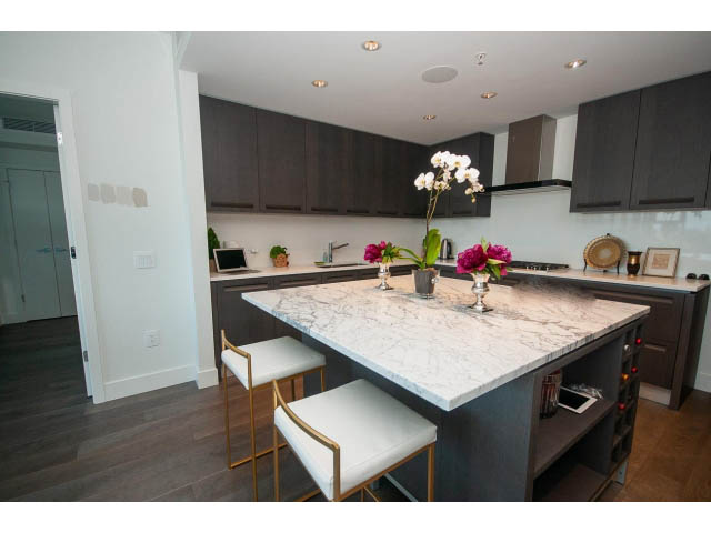 Bright kitchen with marble countertops, dark cabinets, and hardwood floors. - 511 - 2102 W 48th St, Vancouver West Side