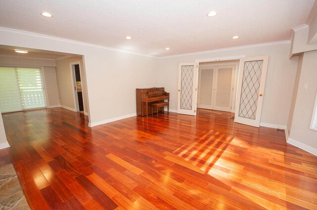 Spacious living room with rich hardwood floors and a grand piano. - 5367 Esperanza Drive, North Vancouver