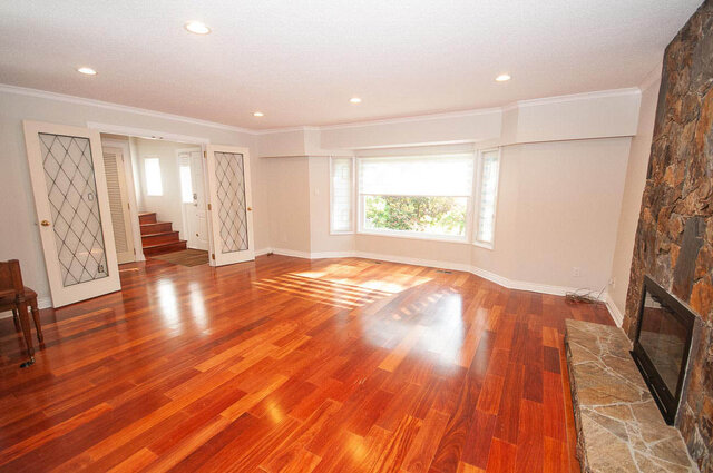 Spacious living room with rich hardwood floors and stone fireplace. - 5367 Esperanza Drive, North Vancouver