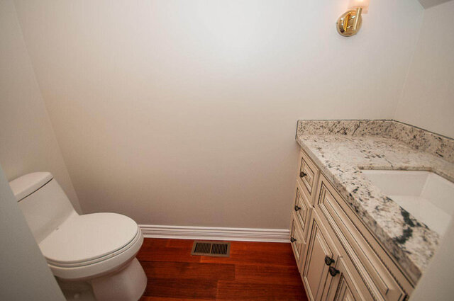 Clean bathroom with granite countertops and rich hardwood flooring. - 5367 Esperanza Drive, North Vancouver