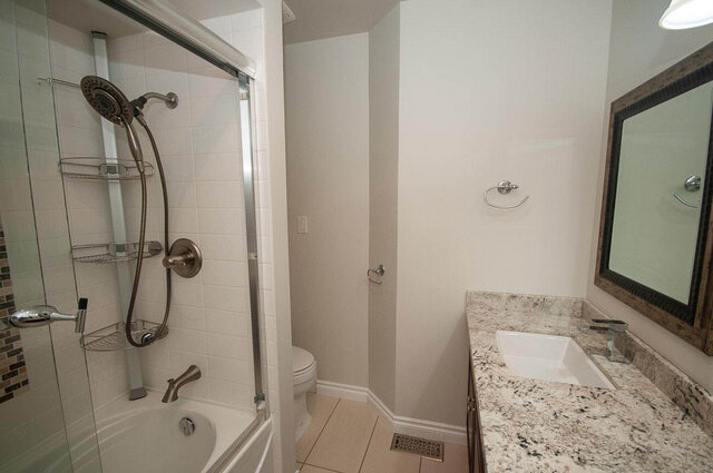 Modern bathroom featuring granite countertops and a glass-enclosed shower. - 5367 Esperanza Drive, North Vancouver