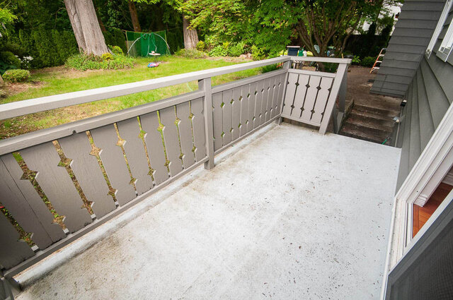 Balcony with gray railing featuring diamond cutouts and lush backyard greenery view. - 5367 Esperanza Drive, North Vancouver