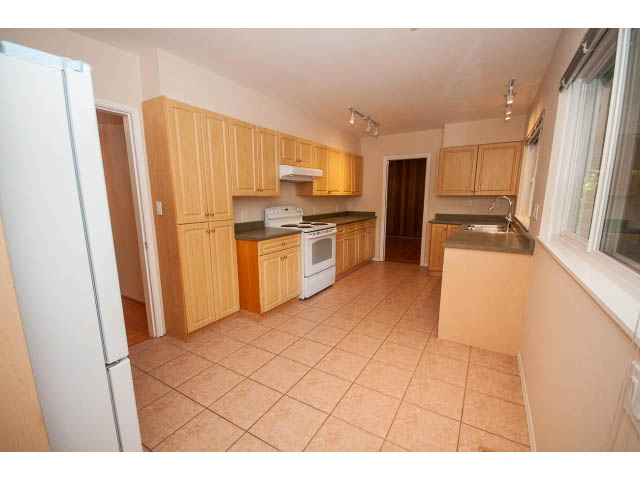 Bright kitchen with light wood cabinets, granite countertops, and a tiled floor. - 315 Stevens Dr, West Vancouver