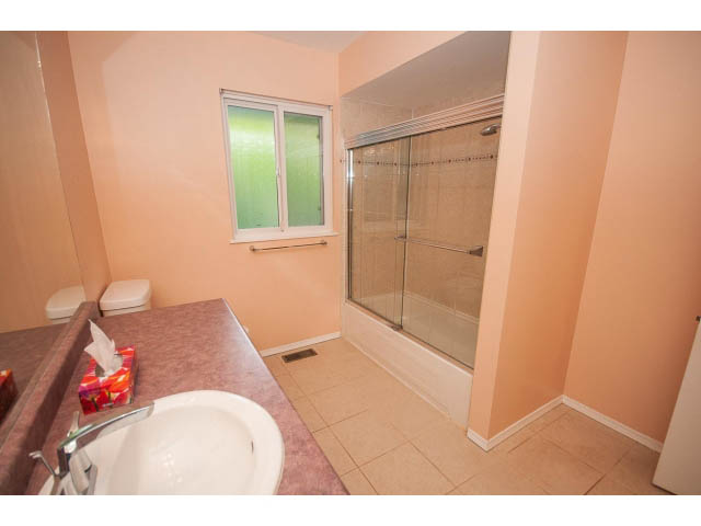 Bathroom with glass shower, pink countertops, and a window view. - 315 Stevens Dr, West Vancouver