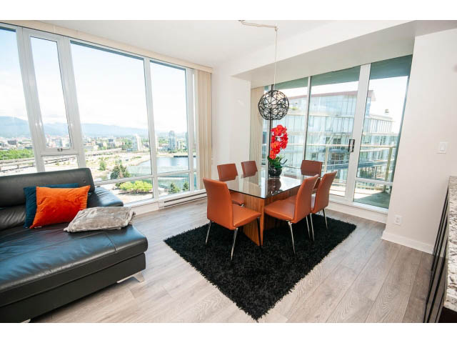 Bright living room with hardwood floors, city view, and modern furnishings. - 2702 - 918 Cooperage Way, Vancouver Downtown