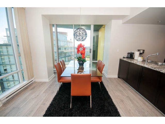Bright kitchen with granite countertops, hardwood floors, and a city view. - 2702 - 918 Cooperage Way, Vancouver Downtown