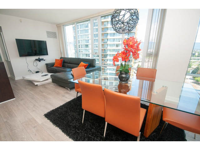 Furnished living room with hardwood floors, city view, and orange chairs. - 2702 - 918 Cooperage Way, Vancouver Downtown
