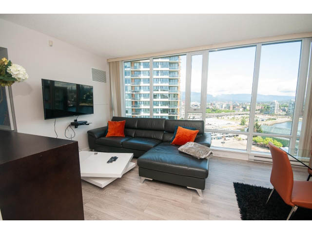 Bright living room with hardwood floors, city view, and modern furnishings. - 2702 - 918 Cooperage Way, Vancouver Downtown