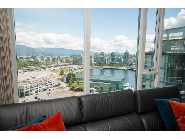 Bright living room with a stunning city view and modern furnishings. - 2702 - 918 Cooperage Way, Vancouver Downtown