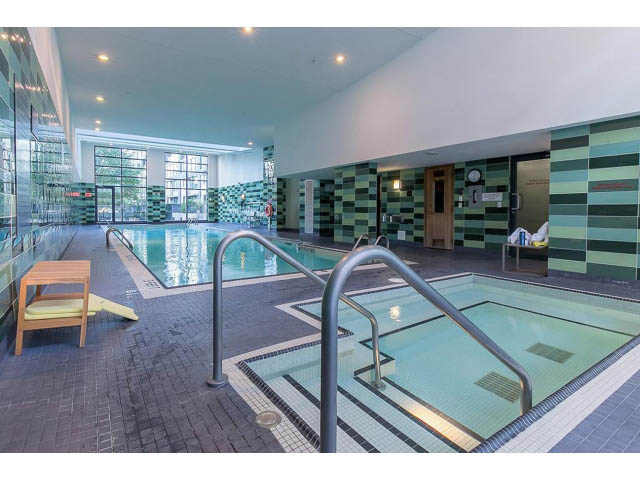 Spacious, modern indoor pool area with green mosaic tiles and city view windows. - 2702 - 918 Cooperage Way, Vancouver Downtown