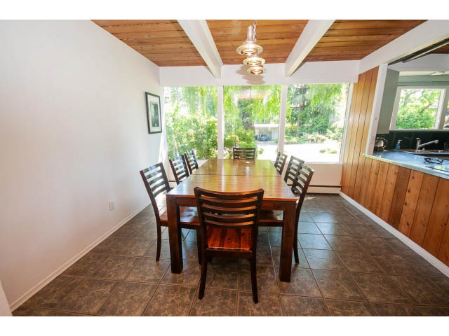 Bright dining area with wooden beams, large windows, and tiled floors. - 640 East Queens Rd, North Vancouver