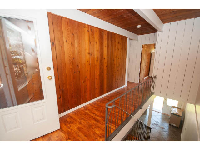 Staircase leading to upper level with wooden walls and hardwood floors. - 640 East Queens Rd, North Vancouver