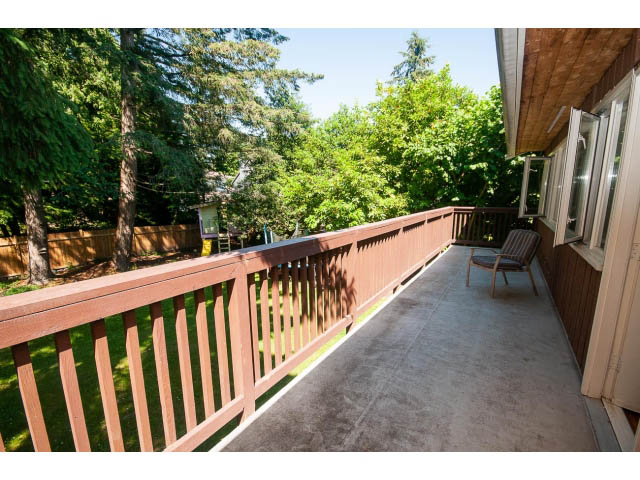 Furnished balcony with wooden railings and a view of greenery. - 640 East Queens Rd, North Vancouver