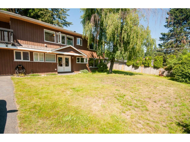 Bright living room with large windows and a grassy backyard. - 640 East Queens Rd, North Vancouver
