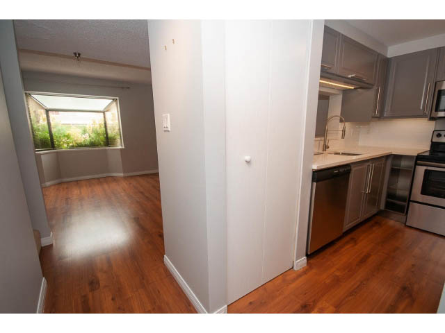 Bright kitchen with stainless steel appliances and hardwood floors. - 123 - 1363 Clyde Avenue, West Vancouver