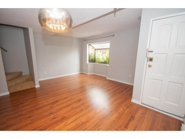 Bright living room with hardwood floors and a window view. - 123 - 1363 Clyde Avenue, West Vancouver