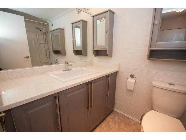 Furnished bathroom with white countertops and gray cabinets. - 123 - 1363 Clyde Avenue, West Vancouver