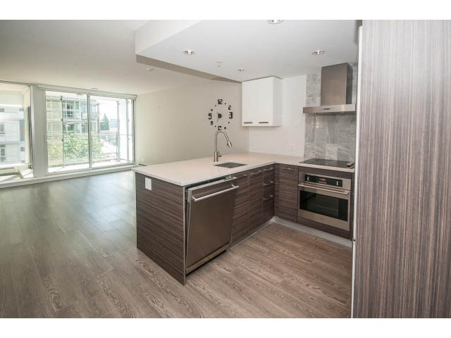 Bright kitchen with modern wood-toned cabinets, stainless steel appliances, and hardwood floors. - 301 - 1783 Manitoba St, Vancouver West Side