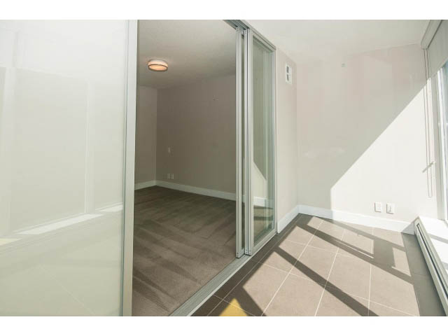 Bright living room with hardwood floors and sliding glass doors leading to a balcony. - 301 - 1783 Manitoba St, Vancouver West Side