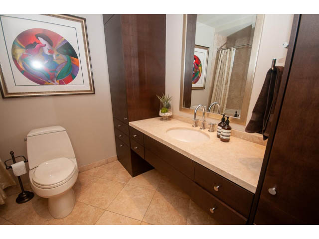 Bright bathroom with beige countertops and a modern sink, featuring a colorful abstract wall art piece. - 3403 - 938 Nelson Street, Vancouver Downtown