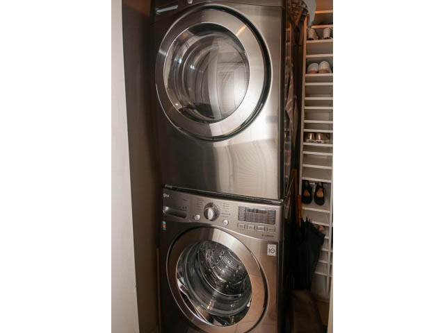 Bright laundry room with stainless steel washer and dryer, neatly organized shelves. - 3403 - 938 Nelson Street, Vancouver Downtown