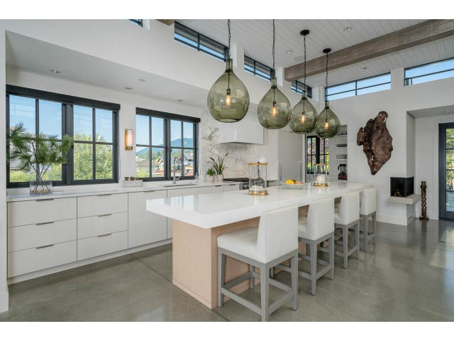 Bright kitchen with white cabinetry, concrete countertops, and large windows offering a city view. - Address WITHHELD, West Vancouver
