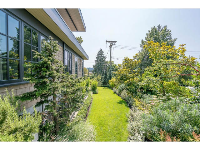 Bright living room with large windows, lush garden view, and modern furnishings. - Address WITHHELD, West Vancouver