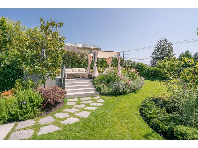 Furnished backyard with stone pathway, lush greenery, and a cozy gazebo. - Address WITHHELD, West Vancouver