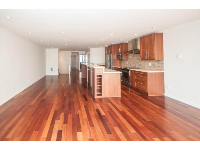 Bright kitchen with hardwood floors and granite countertops, open to living area. - 2150 Argyle Ave., West Vancouver