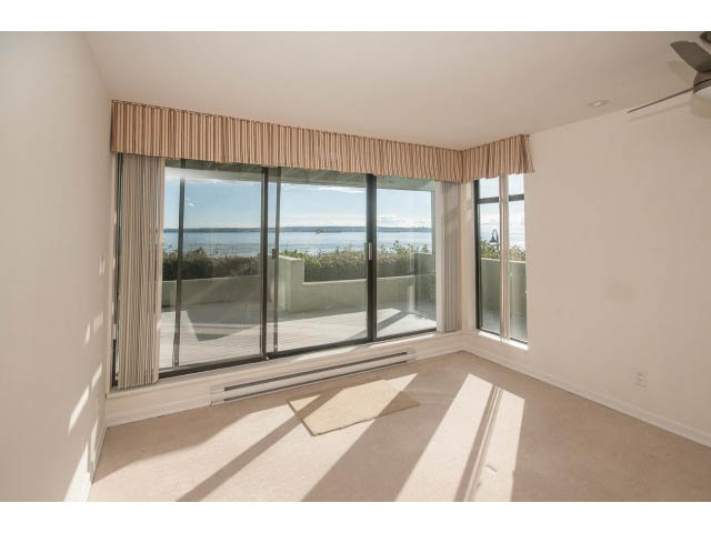 Bright living room with large windows, city view, and carpeted floors. - 2150 Argyle Ave., West Vancouver