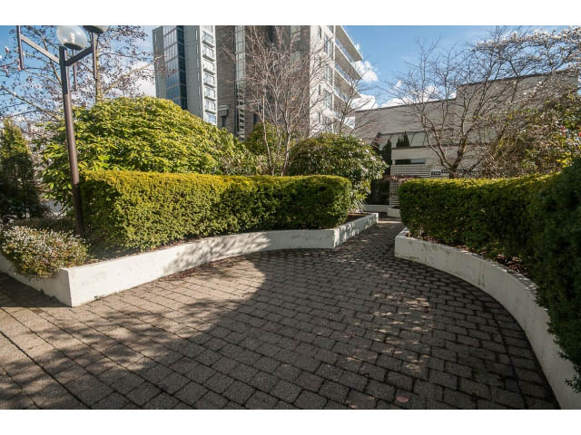 Furnished patio with brick paving and greenery, city skyline in the background. - 2150 Argyle Ave., West Vancouver