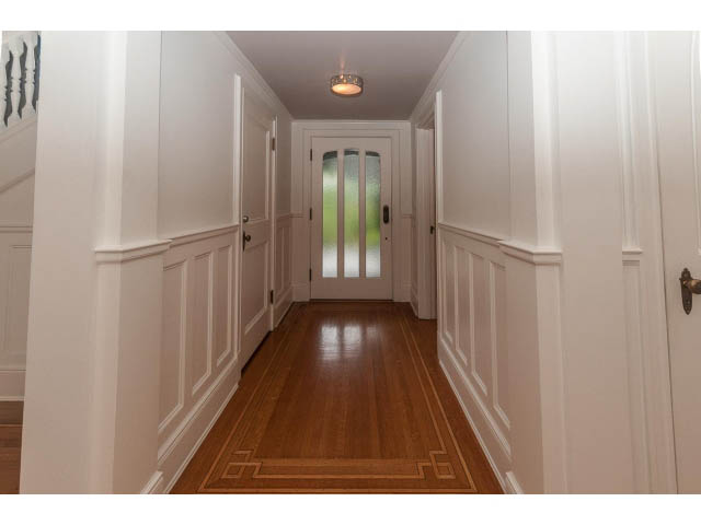 Foyer with white paneling and hardwood floors, leading to a glass door. - 5630 Angus Dr., Vancouver West Side