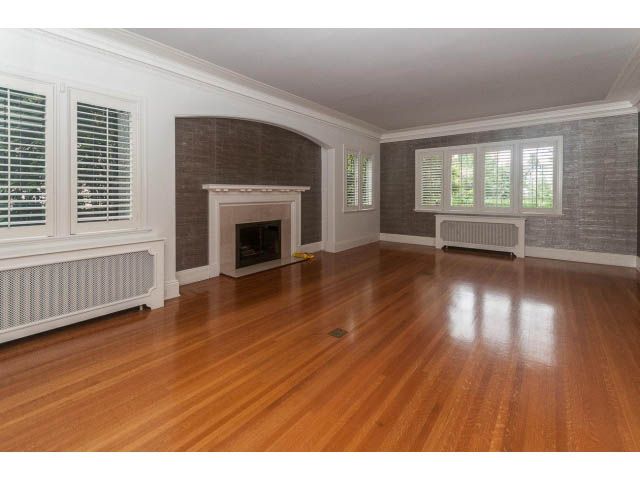 Spacious living room with hardwood floors, large windows, and a fireplace. - 5630 Angus Dr., Vancouver West Side