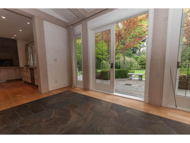 Spacious living room with hardwood floors and large windows showcasing a garden view. - 5630 Angus Dr., Vancouver West Side