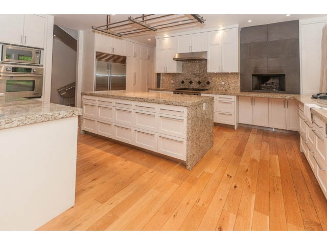 Bright kitchen with granite countertops, hardwood floors, and a modern fireplace. - 5630 Angus Dr., Vancouver West Side