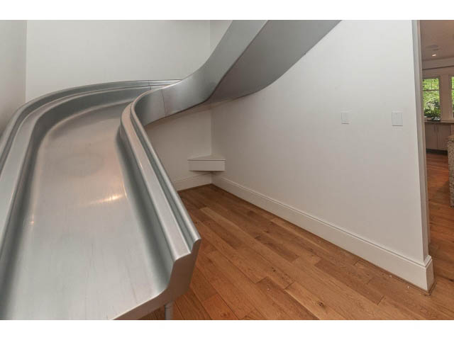 Bright living room with curved metallic slide and hardwood floors. - 5630 Angus Dr., Vancouver West Side