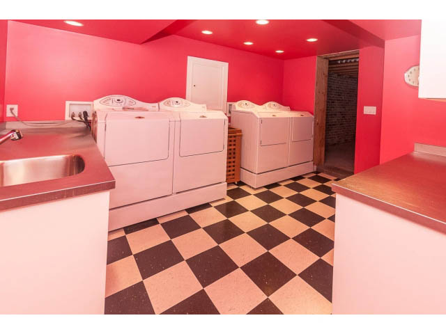 Bright laundry room with pink walls, checkered floor, and stainless steel countertops. - 5630 Angus Dr., Vancouver West Side